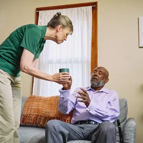 Care Professional bring a client a drink