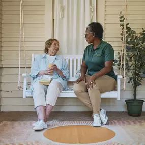 Care Professional sitting with a client on the front porch.