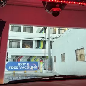 Tunnel exit signage at Olympic Speedwash pointing customers to free vacuum stations—highlighting their end-to-end express wash workflow and complimentary amenities.