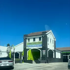 Customer vacuum plaza situated in front of the Northridge Speedwash building. Featuring high-powered vacuums under sunlight and clear traffic arrows, it underlines the convenience offered post-wash with microfiber towels also for purchase.