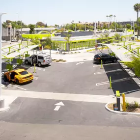 View of parking stalls and vacuum bays near the entrance of the Northridge Speedwash, capturing the organized layout and customer-focused amenities. The tiled structure and visible access lanes promote fast, friendly service.