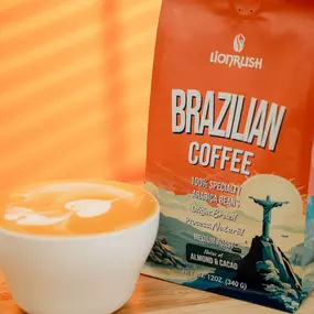 a bag of Brazilian Coffee next to a cup of latte on a wooden table