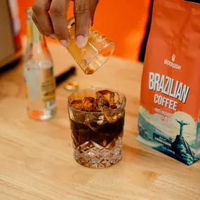iced espresso tonic next to a bag of lionrush coffee