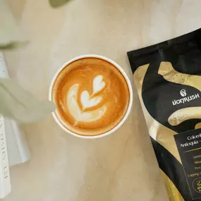 bag of lionrush next to a cup of espresso latte