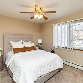 Bedroom with ceiling fan and window coverings