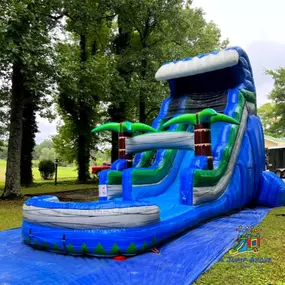 Tropical Splash Water Slide
A tall, tropical-themed inflatable water slide with palm trees, blue waves, and green accents, ending in a splash pool. Great for summer celebrations.