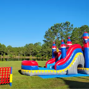 Rocket Lane Combo Bounce House with Dual Slide and Connect 4
A vibrant red, blue, and grey rocket-themed inflatable combo featuring castle turrets, dual slides, and a splash pool. Set up on a sunny lawn beside a pond, with a giant Connect Four game nearby — perfect for outdoor parties and events.