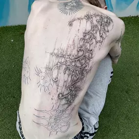 Cyber-Sigilism Blackwork Backpiece mit abstrakten Mustern organischen Linien und dynamischem Schattenspiel.