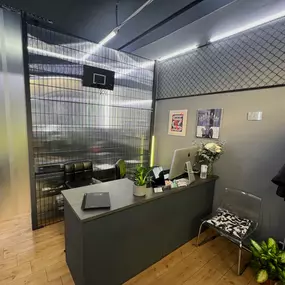 OMEN Lab F-Hain Rezeption mit grauem Tresen und minimalistischem, industriellen Design und modernen Akzenten.