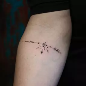 Schriftzug Tattoo mit Ornamenten und Dotwork am Unterarm.