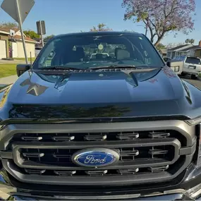 Front view of a black Ford truck with a deep, reflective gloss finish, showcasing Ozzie’s Mobile Detailing’s expert exterior detailing and paint enhancement services in Long Beach, CA.