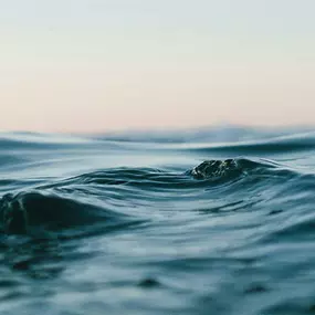 Close-up of calm ocean waves under soft pastel sky