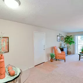 Spacious  living room with a chair and a table and a window