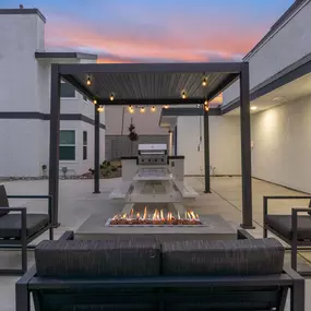 the outdoor patio has a fire pit and seating around it