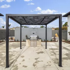 a patio with an outdoor kitchen and a pergola