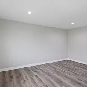 an empty room with wood floors and white walls