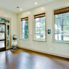 Workout studio that has hardwood floors, ample natural natural light, and cream colored walls