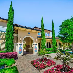 The exterior walkway, lined with trees and florals leading to the leasing office