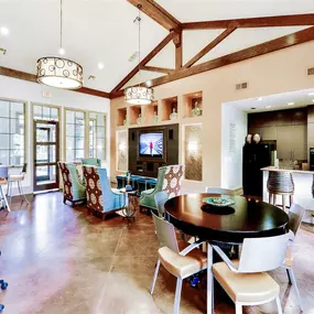 Clubhouse that includes a kitchen island, bar stool seating, an expansive dining area with hardwood floors and tall ceilings
