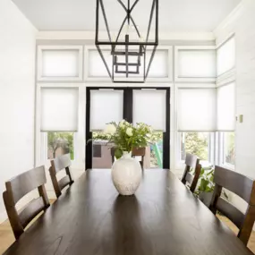 Cellular shades in a neutral dining room.