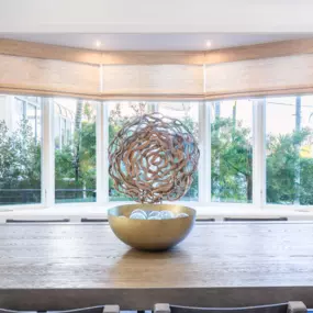 Woven wood shades add warmth and texture while softly filtering light, creating a relaxed, natural feel.