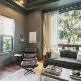 Layered textures and soft, flowing drapery with a structured Roman shade create a cozy yet refined look in this space