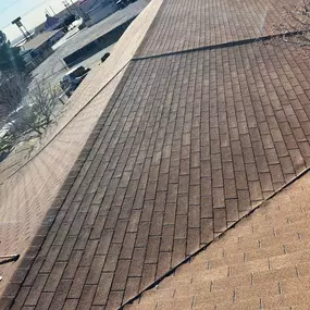 The photo focuses on the details of a shingle roof installation, highlighting the material and its condition.