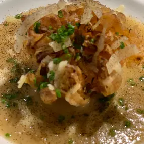 Geschlossene Gesellschaft Nahaufnahme einer edlen Suppe mit knusprigem Topping und frischen Kräutern – Fine Dining bei Geschlossene Gesellschaft von Wulf Mey.