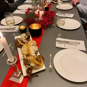 Geschlossene Gesellschaft schafft ein festliches Ambiente mit roten Dekorationen, Kerzen und Vorspeisen für ein unvergessliches Dinner in Hamburg.