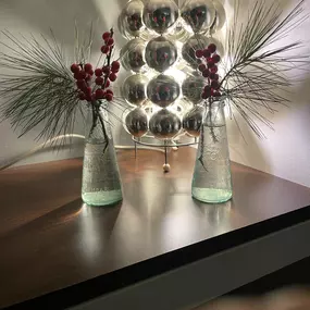 Geschlossene Gesellschaft präsentiert eine elegante Tischdekoration mit Glasvasen, roten Beerenzweigen und einem modernen Lichtobjekt für ein exklusives Ambiente in Hamburg.