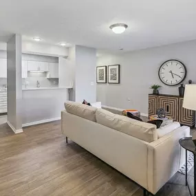 an open living room and kitchen with a large clock on the wall