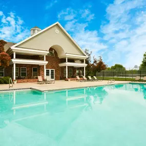 A house with a pool in front of it.