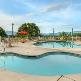 Three outdoor pools with seating and umbrellas at Sunrise Ridge Resort