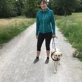 In unserer Ausbildung steht die enge Zusammenarbeit zwischen Mensch und Hund im Vordergrund. Hier begleitet ein Blindenführhund seine Halterin sicher durch die Natur.
