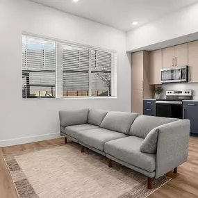 Spacious living room with tall ceilings and wood like flooring throughout.