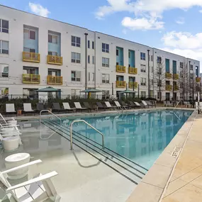 Resort-style swimming pool with lounge chairs and shaded seating at Skylark Apartments in Atlanta.