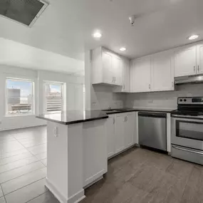 A modern kitchen with stainless steel appliances and white cabinets.