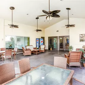 Outdoor patio area with ample seating, glass tables with chairs, a vending machine, and multiple outdoor fans
