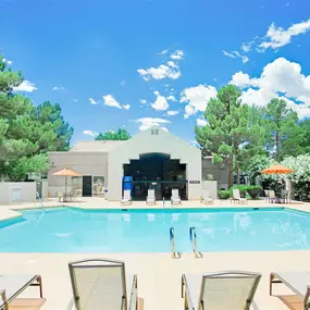 Heated pool with beige lounge chairs in front of it