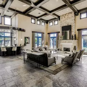 Leasing office with huge windows, wooden beams, lounge area and tile flooring