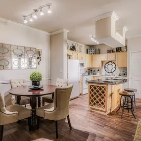 View of a connected dining room and kitchen with white walls and wood flooring