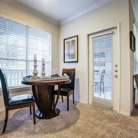 A dining room with a table and chairs.