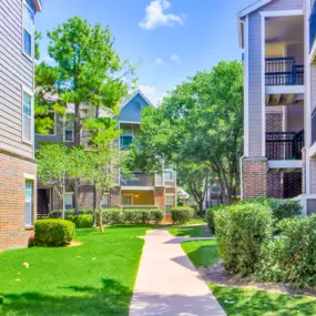 Walk way with green lawn and bushes