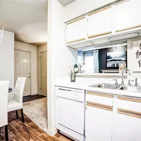 Kitchen with white appliances and dining table with chairs