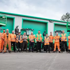 Group photo of a Sunbelt Rentals depot team standing outside the depot with equipment in the background.