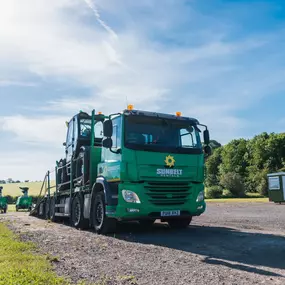 Sunbelt Rentals branded green delivery lorry transporting equipment in a rural location.