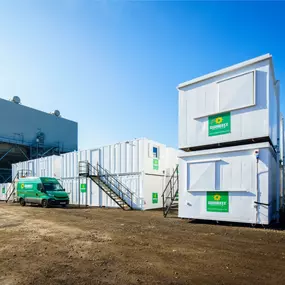 Sunbelt Rentals branded welfare cabins on-site with a green delivery van parked nearby.