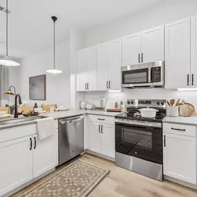 Modern kitchen with white cabinets, stainless steel appliances, and a center island.