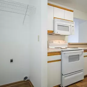 A white oven is in a kitchen with white cabinets.