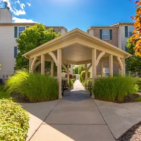 A gazebo-like structure is in the middle of a walkway between two buildings.